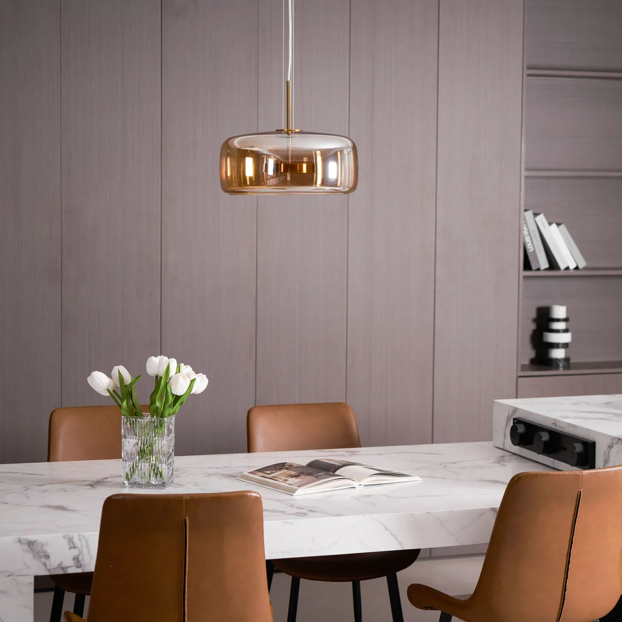 suspension en verre fumé ambre brillant au dessus d'une table à manger moderne